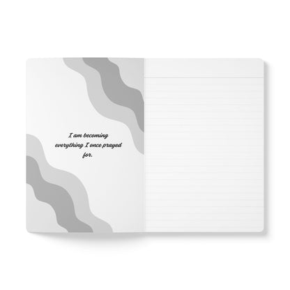 Notebook with gray wavy design and motivational quote on a white background